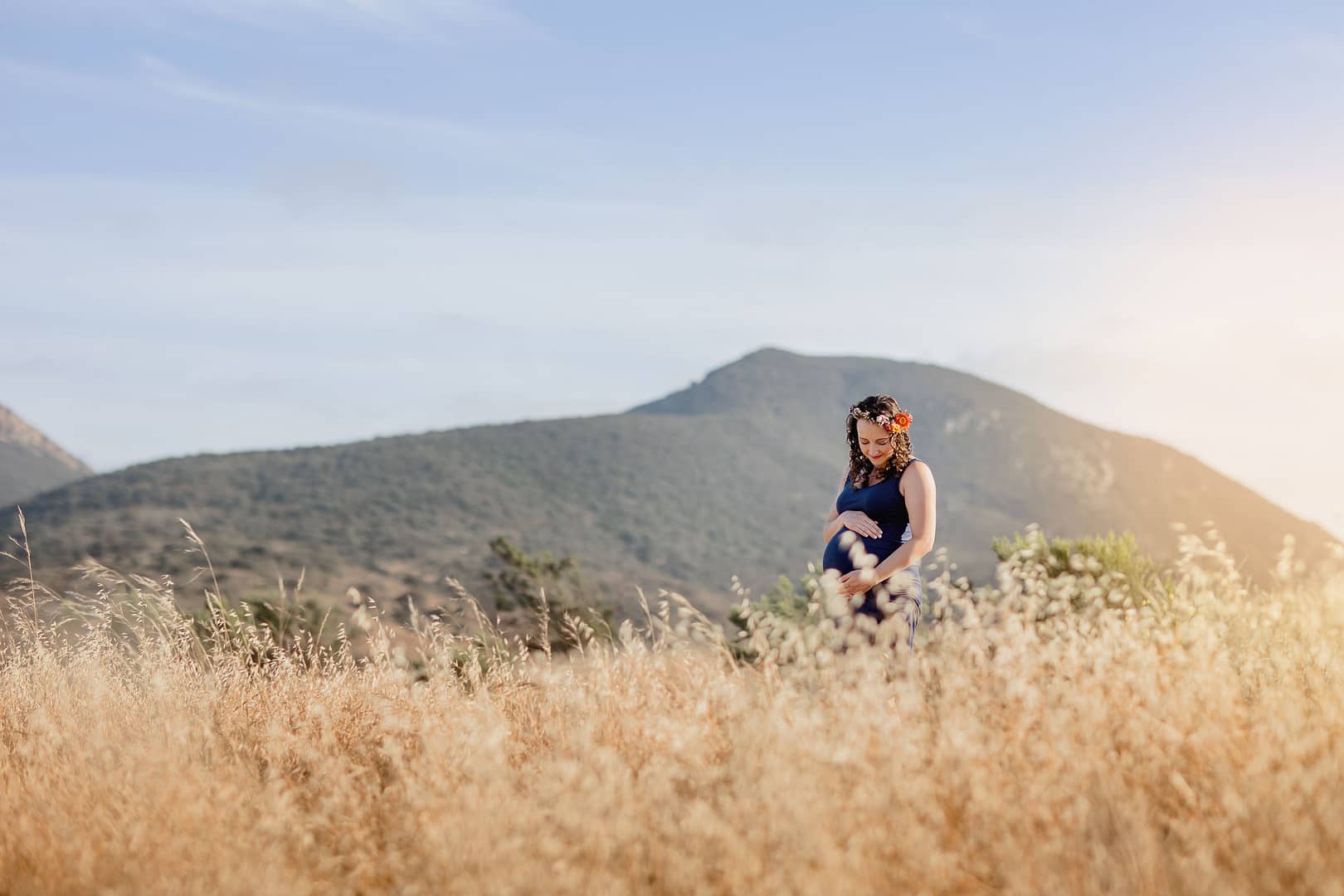 San Diego Maternity Photography of mom in Mission Trails, with beautiful golden sunlight and tall golden grass surrounding mom