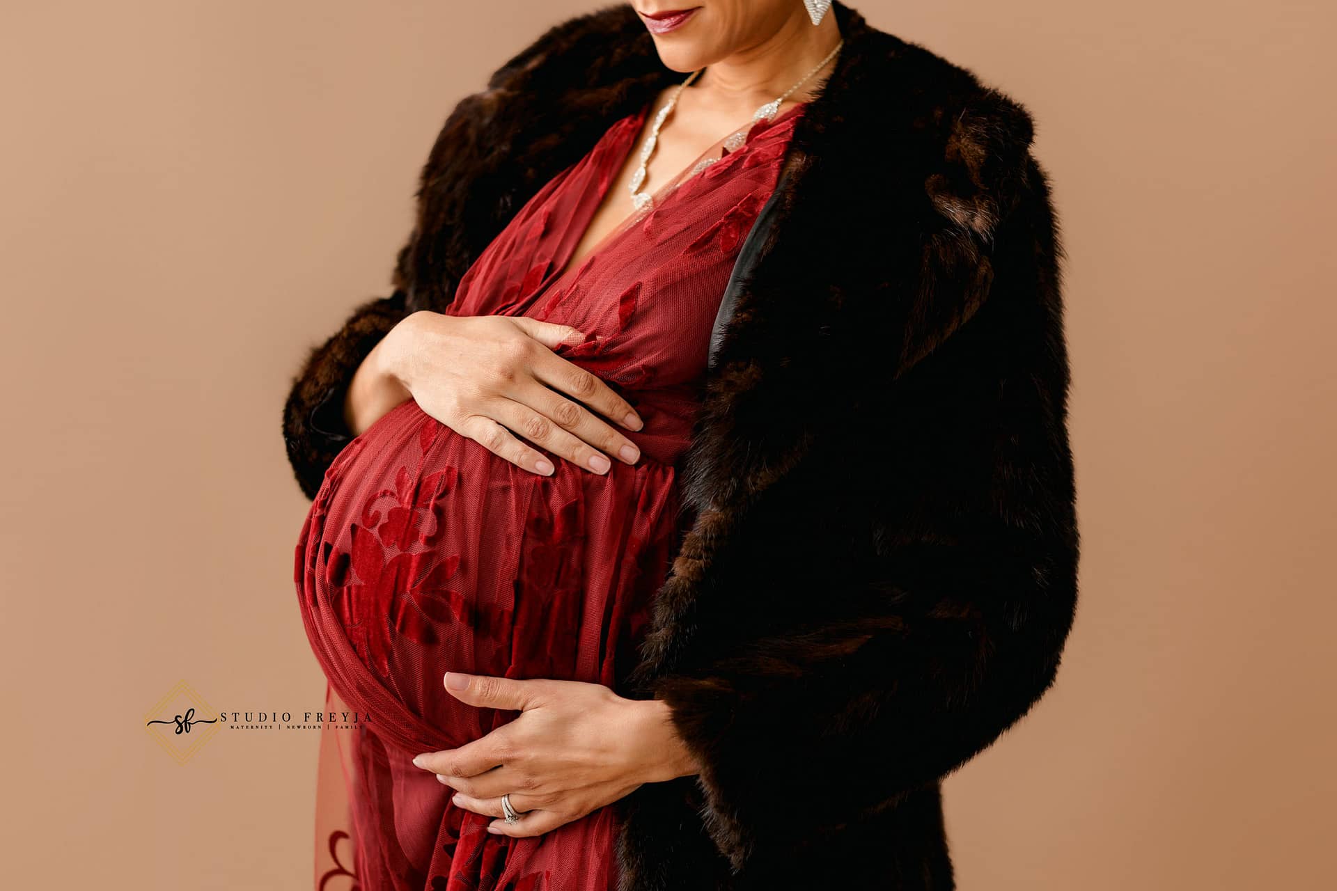 Up close image of pregnant belly during maternity session in studio