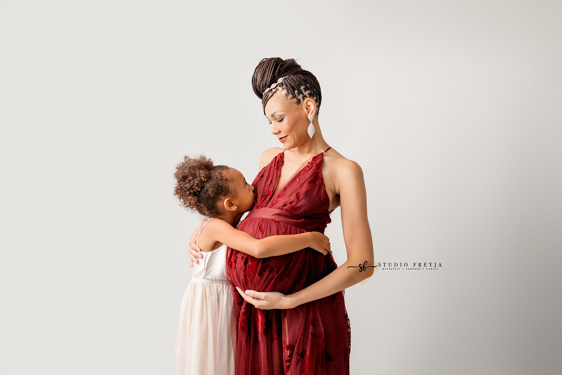 Mom hugging oldest daughter during San Diego maternity pictures